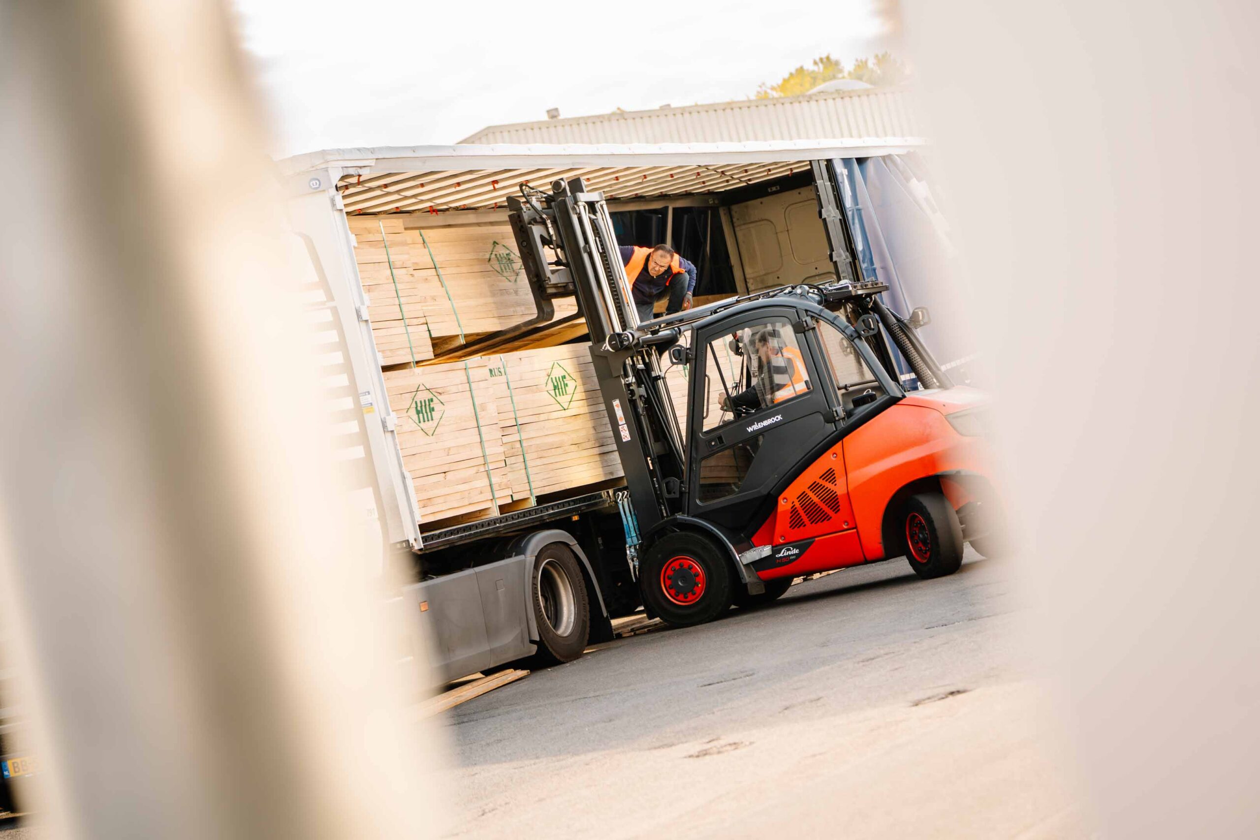 Ein Gabelstapler belädt den LKW mit Schnittholz