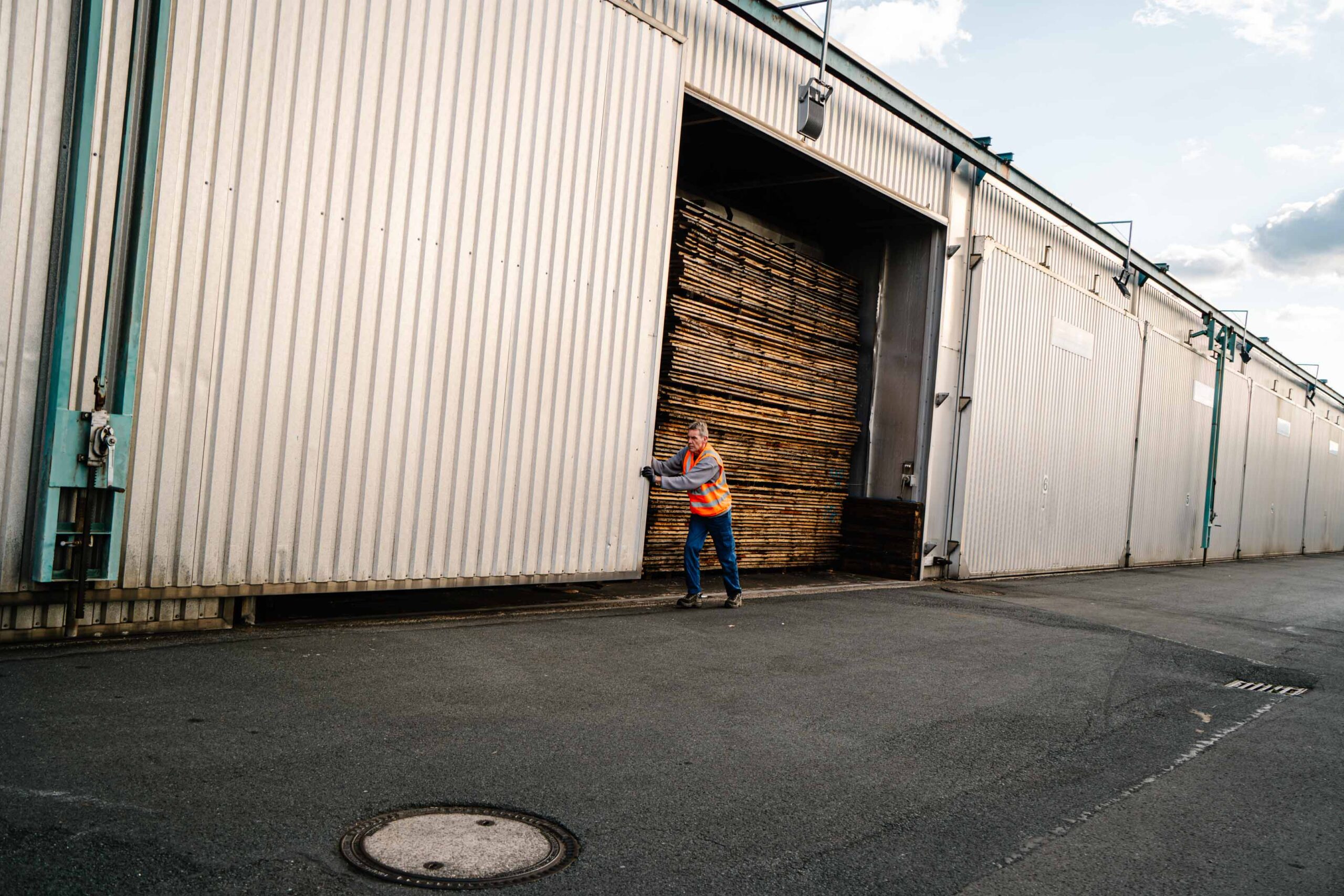 Ein Hallentor wird geöffnet, hinter dem das Holz getrocknet wurde