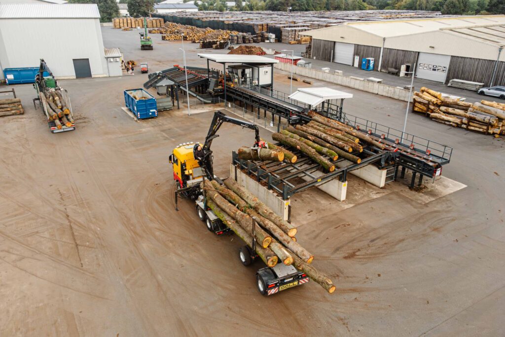 Rundholzablängstation wird von einem LKW beladen.